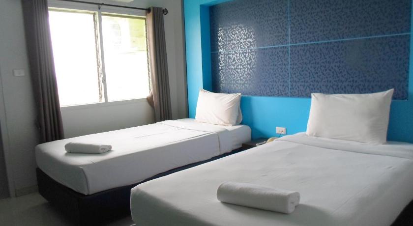 a hotel room with two beds and a window, Phongkaew Hotel in Surat Thani