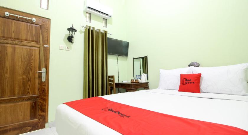 a hotel room with a bed and a television, RedDoorz Plus near Taman Sari in Yogyakarta