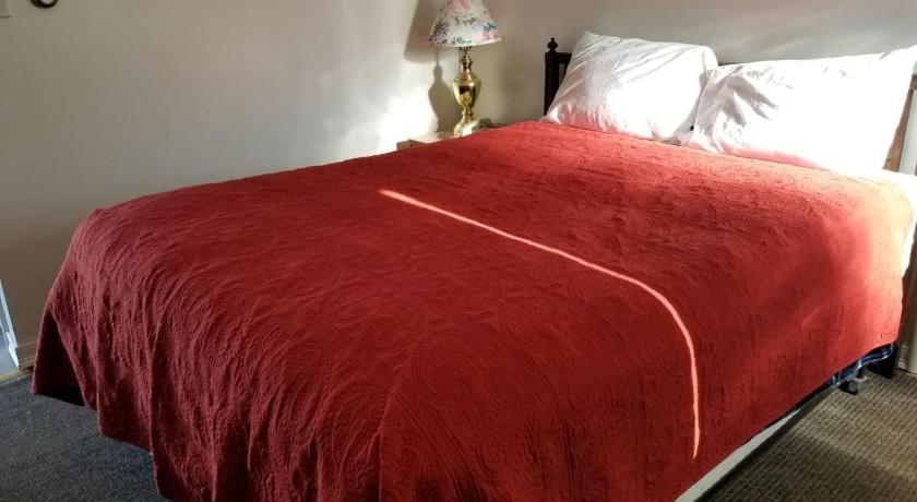 a bed that has a red blanket on top of it, Shiva's Travelers Lodge in Niagara Falls (NY)