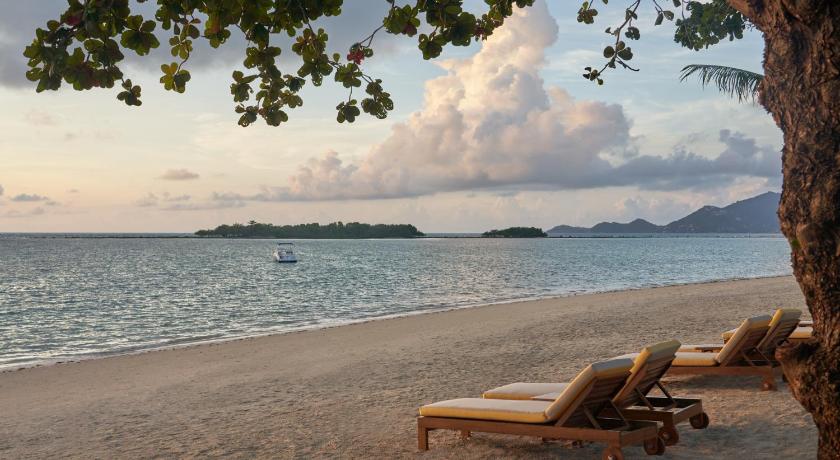 a beach with chairs and a bench on it, SALA Samui Chaweng Beach Resort  (SHA Extra Plus) in Koh Samui