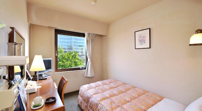 a bedroom with a bed, desk and a television, Hotel Keifuku Fukui Ekimae in Fukui