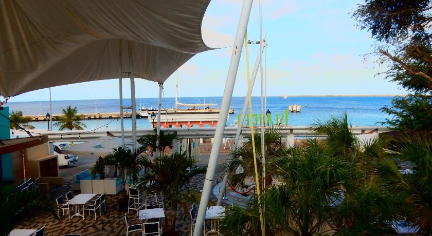 a patio area with chairs and umbrellas, Hotel Islander Bonaire in Kralendijk