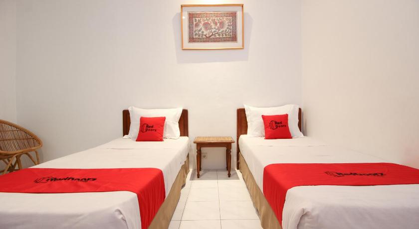 a hotel room with two beds and two lamps, RedDoorz Plus near Alun Alun Selatan 2 in Yogyakarta