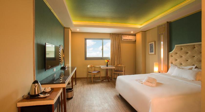 a hotel room with a bed, desk, chair and a lamp, Appleton Boutique Hotel Cebu in Cebu