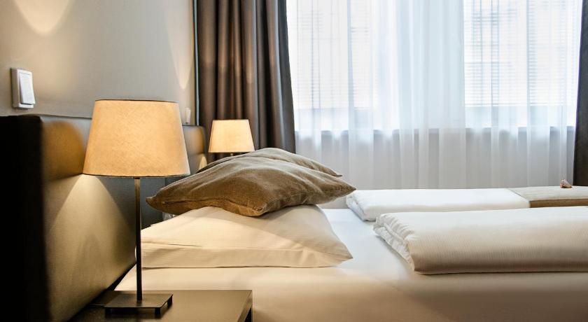 a hotel room with a bed and a lamp, The Corner Hotel in Frankfurt am Main