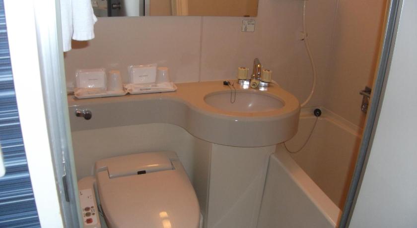 a white toilet sitting next to a sink in a bathroom, Smile Hotel Towada in Towada