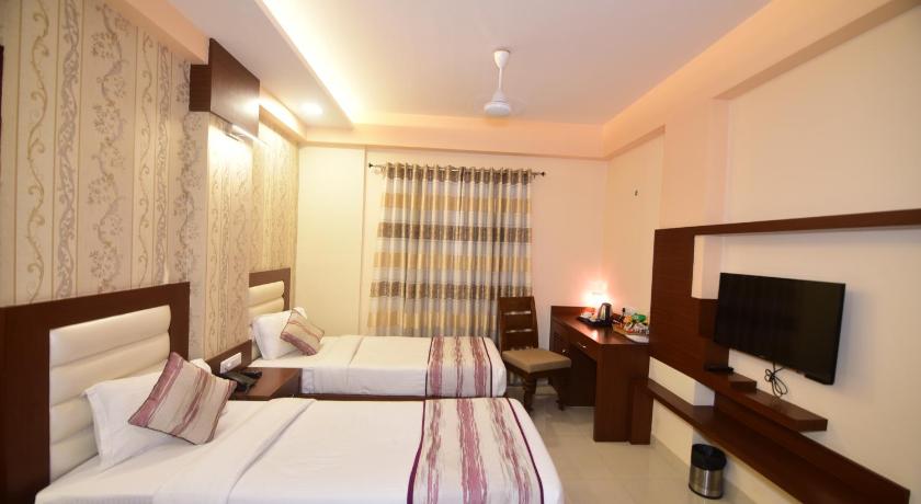 a hotel room with a bed and a television, Hotel Varanasi Inn in Varanasi