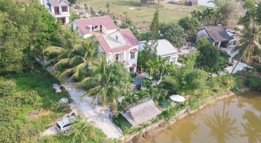a large body of water with houses and trees, Tra Que Riverside Homestay in Hoi An