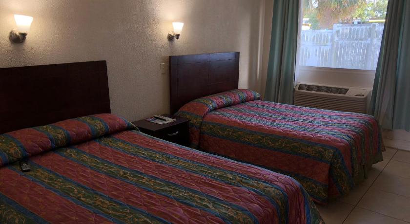 a hotel room with two beds and two lamps, Sunset Inn- Fort Pierce, FL in Fort Pierce (FL)