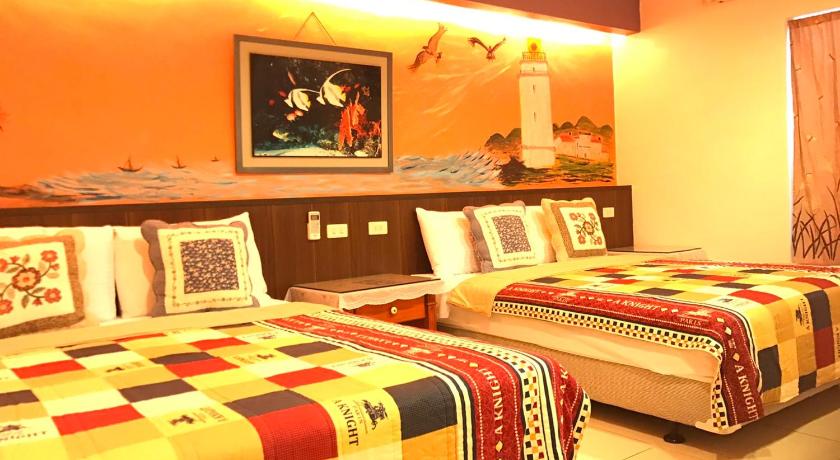 a bed room with two beds and a table, Nan Wan KiKi B&B in Kenting