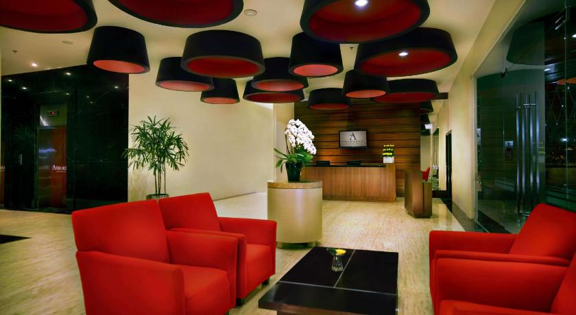 a living room filled with furniture and a red couch, Atria Residences Gading Serpong in Tangerang