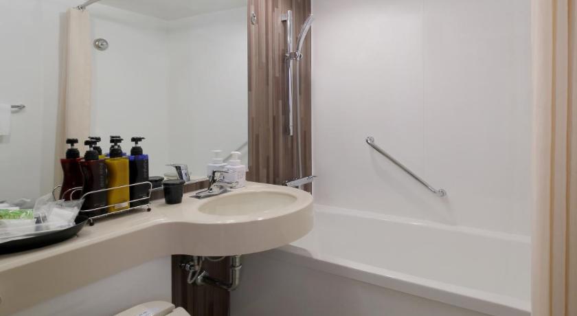 a bathroom with a toilet, sink, and bathtub, Hotel Metropolitan Yamagata in Yamagata