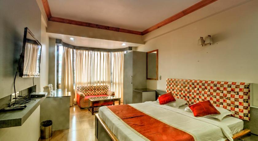 a hotel room with two beds and a television, Hotel Gateway Shillong in Shillong