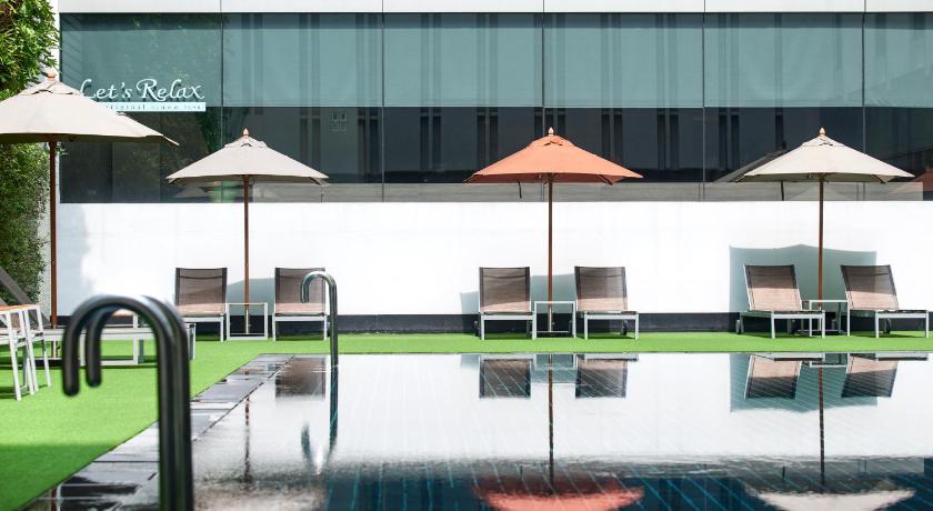 a patio area with chairs, tables and umbrellas, Mandarin Hotel Managed by Centre Point (SHA Plus+) in Bangkok