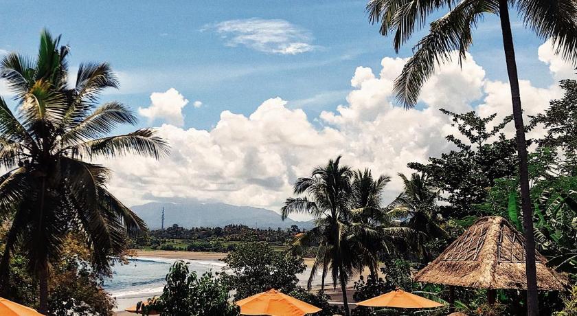 a beach with palm trees and palm trees, Puri Dajuma Beach Eco Resort & Spa in Bali