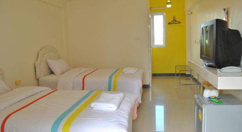 a hotel room with two beds and a television, O.U.M.HOTEL in Uttaradit