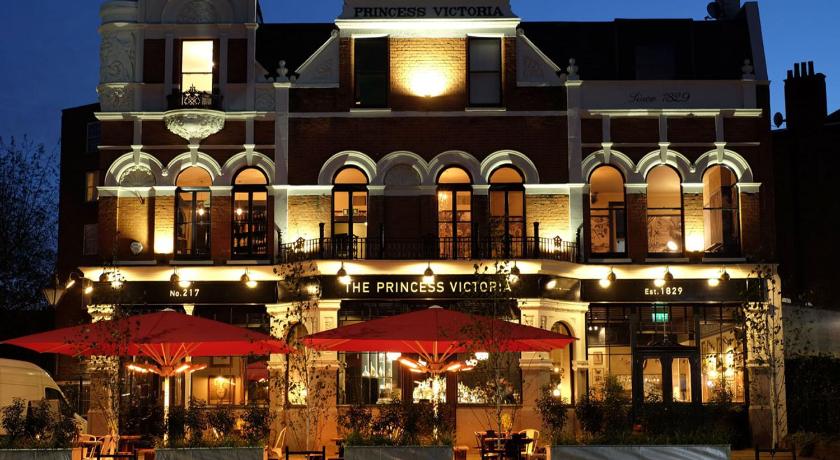 a large building with tables and umbrellas in front of it, The Princess Victoria in London