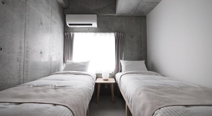 a bedroom with a bed and a window, Smi:re Stay Oshiage in Tokyo