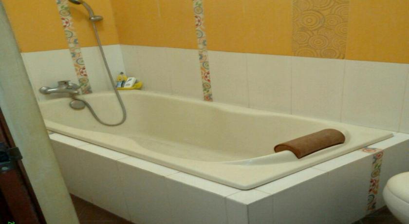 a bath tub sitting next to a toilet in a bathroom, Seventeen homestay in Bandung