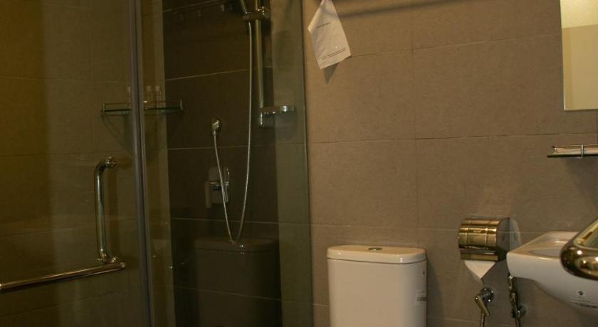 a white toilet sitting in a bathroom next to a shower, Prince 33 Hotel in Johor Bahru