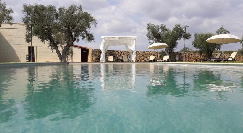 a pool with umbrellas on top of it, Masseria San Polo in Squinzano