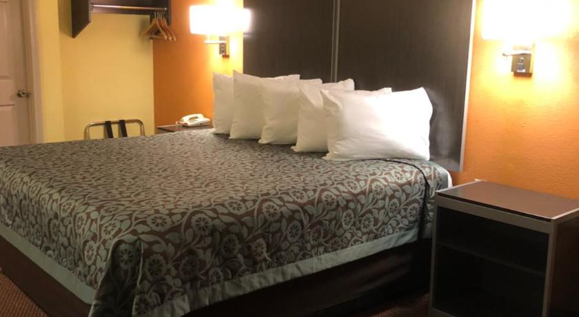 a bedroom with a bed and a night stand, Days Inn by Wyndham Childersburg in Childersburg (AL)