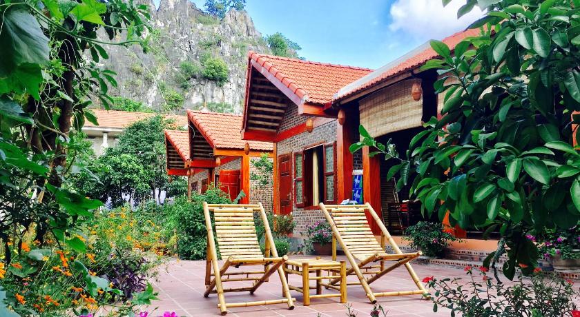 a wooden bench sitting in front of a lush green garden, Tam Coc Friendly Homestay in Ninh Bình
