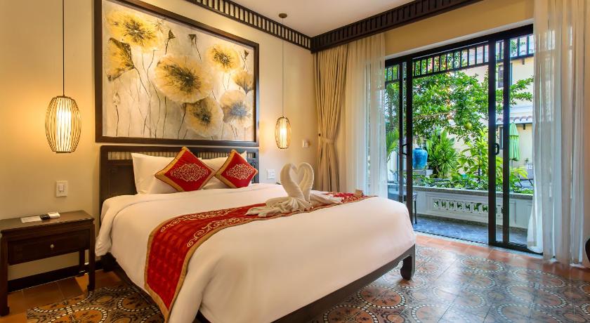 a hotel room with a large bed and a large window, Hoi An Field Boutique Resort & Spa in Hoi An