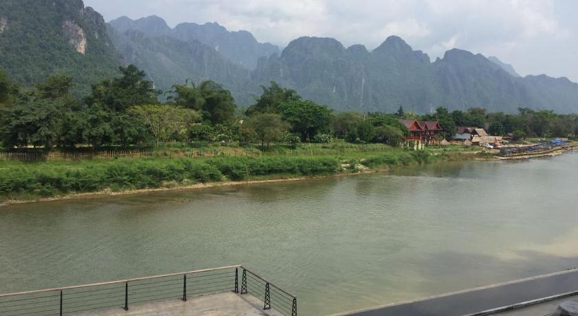 a view of a river from a bench overlooking a city, Inthira Vang Vieng in Vang Vieng