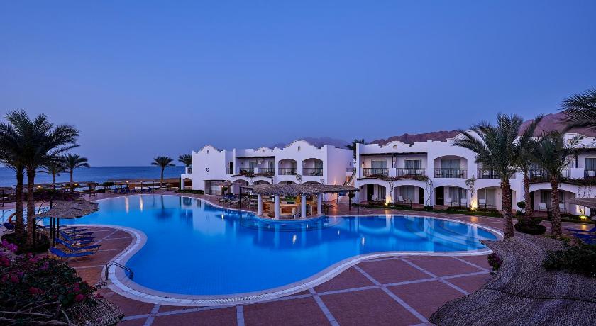 a hotel room with a pool and a balcony, Jaz Dahabeya Resort in Dahab
