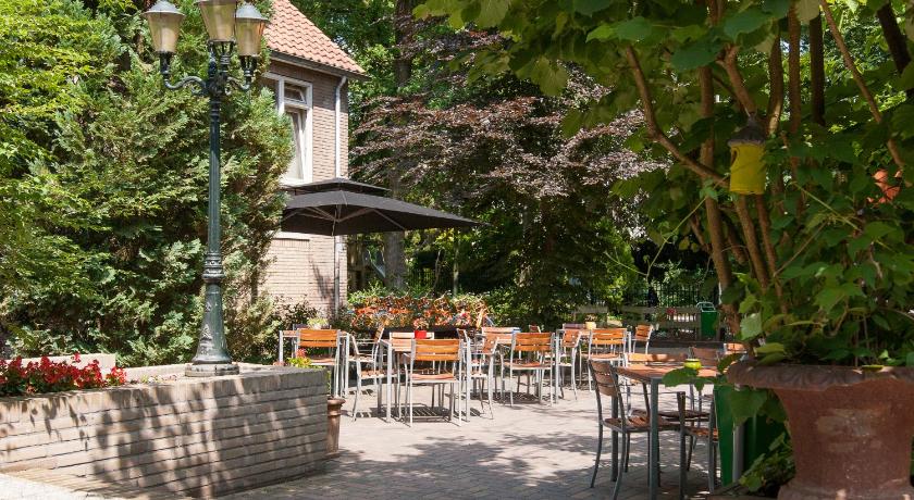 a patio area with tables and chairs and umbrellas, Stayokay Hostel Arnhem in Arnhem