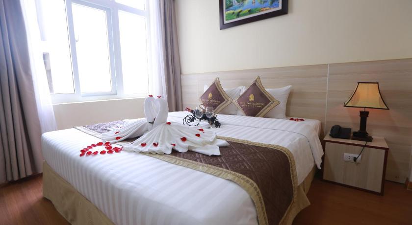 a bed with a white bedspread and pillows in a bedroom, Tecco Sky Hotel & Spa in Vinh