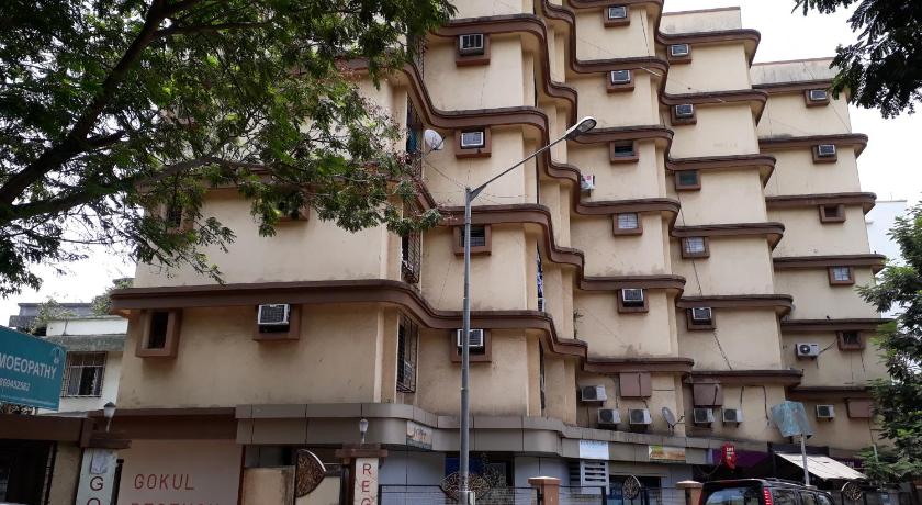 a city street with cars parked in front of a building, Dragonfly Apartments Crystal in Mumbai