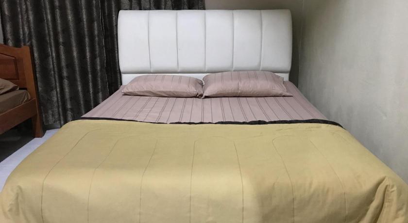 a bed with a white comforter and pillows, Homestay Hani in Arau