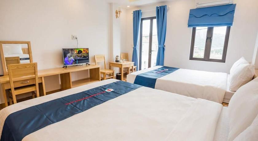a hotel room with a bed and a television, Cat Ba Valentine Hotel in Cat Ba Island