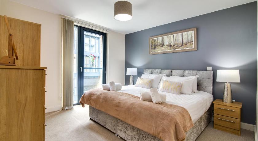 a bedroom with a large bed and a large window, Arcadian City Centre Apartment in Birmingham