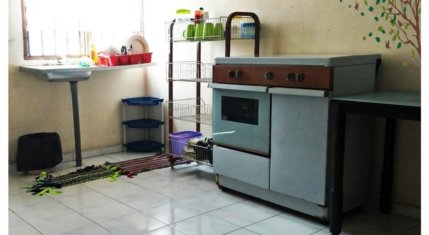a kitchen with a stove and a microwave, Homestay Melewar in Batu Pahat