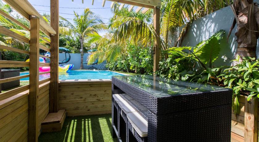 a room with a pool, a tub, and a chair, Tropical Garden Bungalow in West Palm Beach (FL)