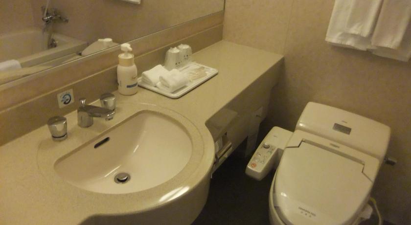 a white toilet sitting next to a sink in a bathroom, Yaoji Hakata Hotel in Fukuoka