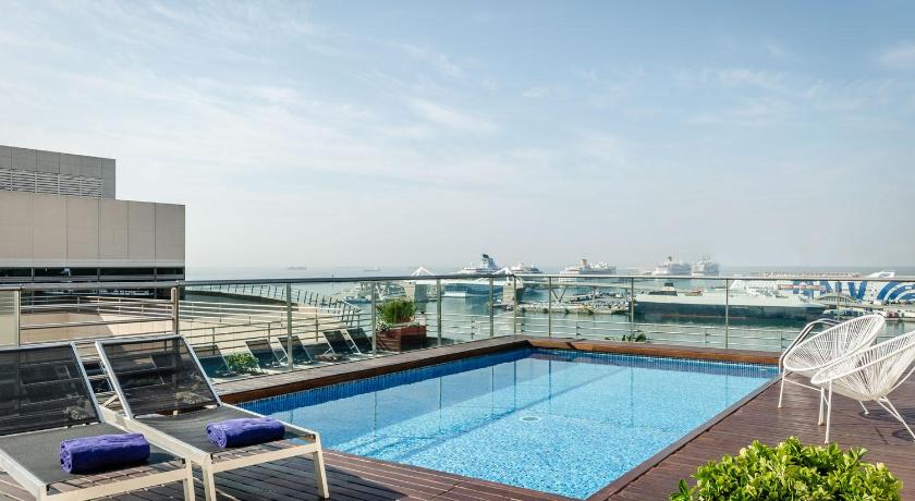 a pool with chairs and a pool table in it, Eurostars Grand Marina Gl Hotel in Barcelona