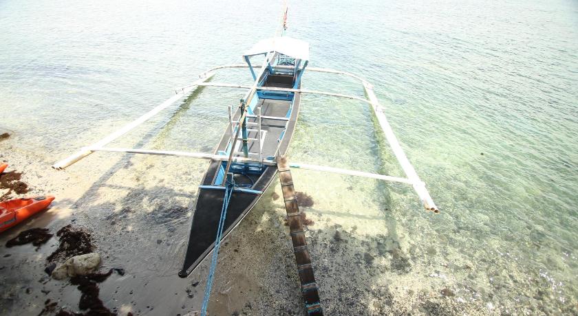 a small boat sitting on top of a body of water, Altamare Dive and Leisure Resort in Batangas