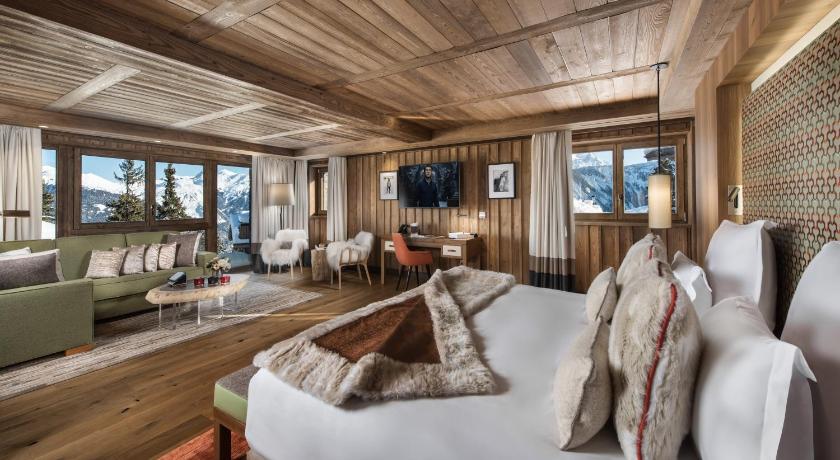 a living room filled with furniture and a large window, Hotel Barriere Les Neiges Courchevel in Saint-Bon-Tarentaise