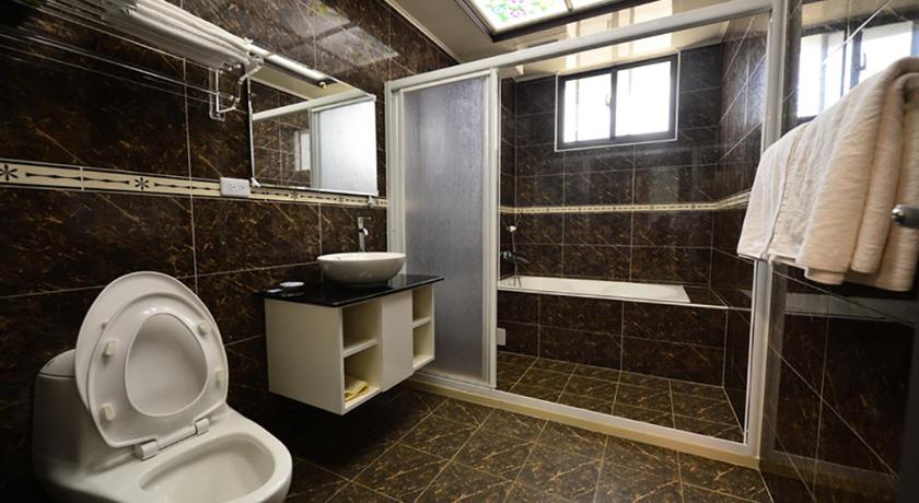 a bathroom with a toilet, sink, and shower stall, De Mei Homestay in Penghu