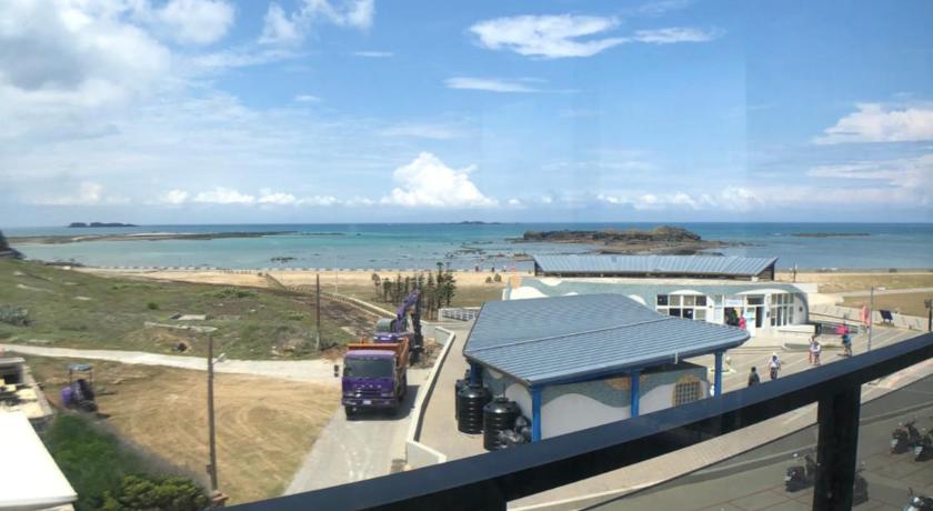 a view from a car window of a beach with a view of the ocean, Hygge Homestay in Penghu