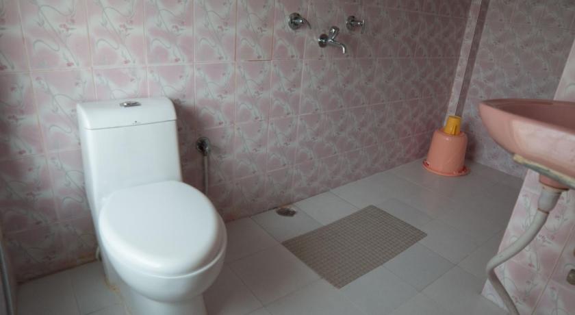 a white toilet sitting next to a white sink, Galaxy Guest House in Siddharthanagar