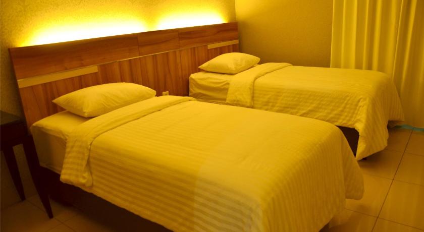 a hotel room with two beds and two lamps, MTC Mega Mas Apartment in Manado