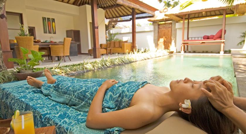 a woman laying on top of a bed in a swimming pool, Ellora Villas in Bali