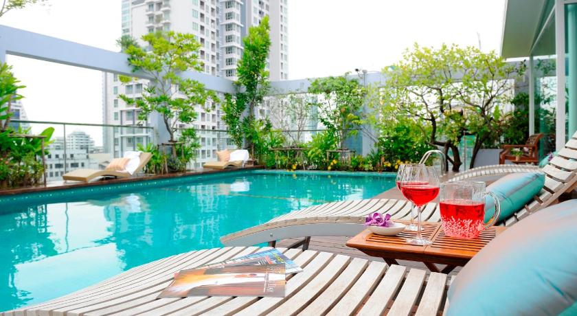 a patio area with tables, chairs, and umbrellas, Sabai Sathorn Serviced Apartment in Bangkok