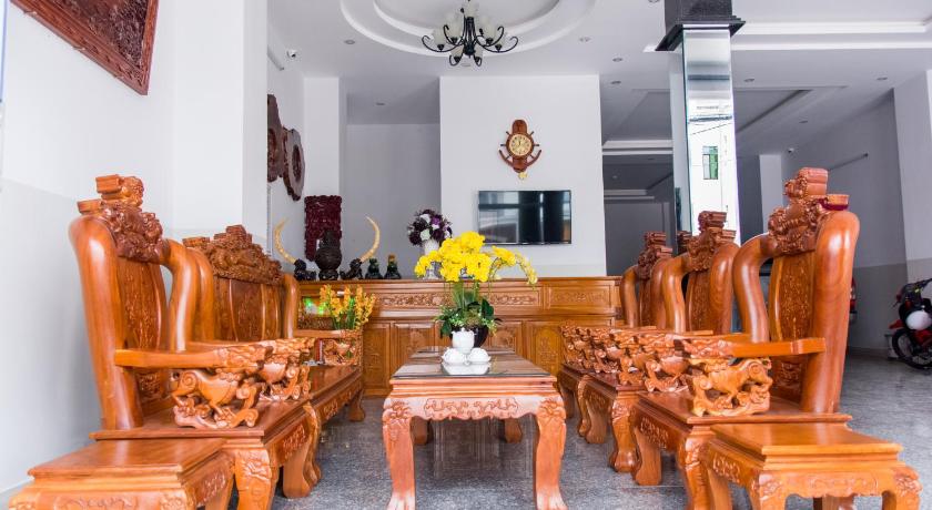 a dining room table with chairs and a vase of flowers, Hoang Thinh Hotel in Kon Tum