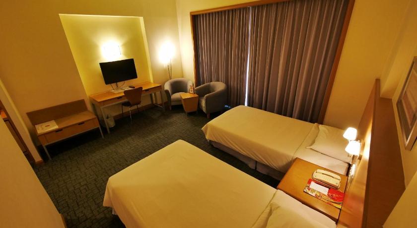 a hotel room with two beds and a television, Premier Hotel Sibu in Sibu